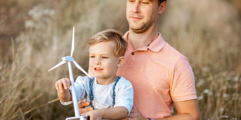 Father and young son playing with wind turbine
